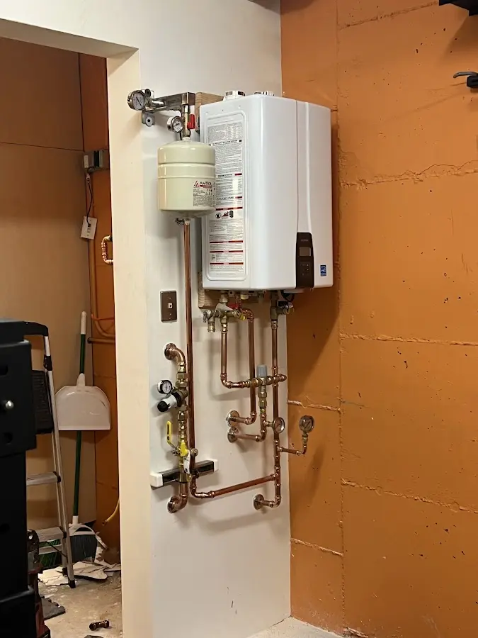 Plumbing technician inspecting water heater connections in Highland Springs